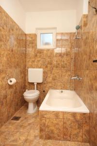 een badkamer met een bad en een toilet bij Apartments by the sea Podaca, Makarska - 6821 in Podaca