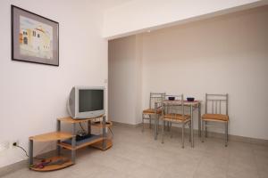 uma sala com mesas e bancos e uma televisão em Apartments with a parking space Maslenica, Novigrad - 6548 em Jasenice
