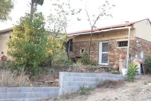 una pequeña casa de piedra frente a un patio en Casa da Abelha- Beehouse 