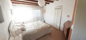 una camera da letto con un letto con lenzuola bianche e una finestra di Casa da Abelha- Beehouse 