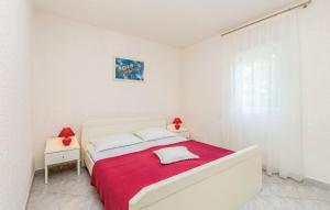 een witte slaapkamer met een groot bed met een rode deken bij Apartments and rooms with parking space Novi Vinodolski - 19963 in Novi Vinodolski