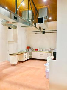 uma grande cozinha com armários brancos e uma mesa em Metro Adventurer Backpackers em Auckland