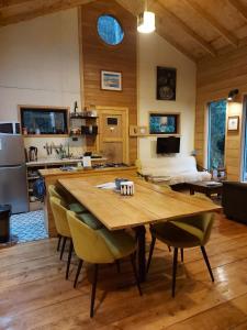 a kitchen and dining room with a wooden table and chairs at Casa Molino de Chiloé in Castro +13 photos