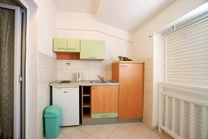 una pequeña cocina con armarios verdes y naranjas en Apartments with a parking space Baska Voda, Makarska - 6827, en Baška Voda