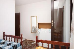 um quarto com uma cama, um espelho e um frigorífico em Twin Room Podaca 6824c em Podaca