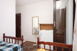 ポダツァにあるTwin Room Podaca 6824cのベッドルーム1室(ベッド1台、鏡、冷蔵庫付)