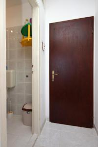 uma porta castanha numa casa de banho com WC em Twin Room Podaca 6824c em Podaca