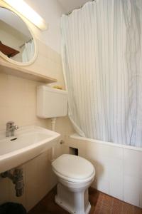 a bathroom with a toilet and a sink and a mirror at Apartments with a parking space Podgora, Makarska - 6645 in Podgora