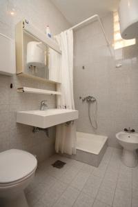 a bathroom with a toilet and a sink and a shower at Apartments by the sea Zivogosce - Blato, Makarska - 6797 in Igrane +24 photos