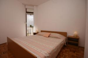 a bedroom with a bed and a window at Apartments by the sea Zivogosce - Blato, Makarska - 6797 in Igrane