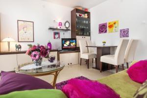 una sala de estar con una mesa con un jarrón de flores en Apartments by the sea Makarska - 6843, en Makarska
