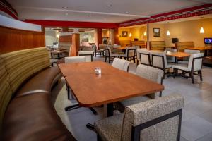 Holiday Inn Hotel & Suites Beckley, an IHG Hotel في بيكلي: غرفة طعام مع طاولات وكراسي في مطعم