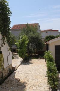 kamienny dziedziniec z drzewami i budynek w obiekcie Apartments with a parking space Povljana, Pag - 6501 w mieście Povljana