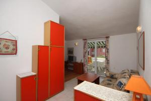 une cuisine avec des placards rouges et un salon dans l'établissement Apartments with a parking space Povljana, Pag - 6501, à Povljana