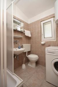 La salle de bains est pourvue de toilettes et d'un lavabo. dans l'établissement Apartments with a parking space Povljana, Pag - 6501, à Povljana