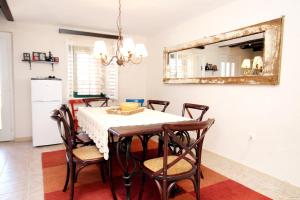 a dining room with a table with chairs and a mirror at Holiday house with a parking space Gornji Tucepi - Tomasi, Makarska - 6818 in Tučepi