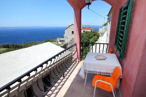 a balcony with a table and chairs and the ocean at Holiday house with a parking space Gornji Tucepi - Tomasi, Makarska - 6818 in Tučepi