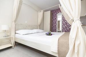 a bedroom with a white bed with a canopy at Apartments with swimming pool Tucepi, Makarska - 6817 in Tučepi