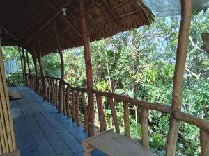 un porche de una casa con vistas al bosque en Hostel Del Lago Yojoa Backpackers, en Agua Azul