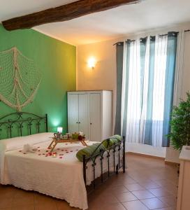 - une chambre avec un lit et un mur vert dans l'établissement Casa Domitilla Vista Mare - Spiagge, Storia & Relax Wifi - Netflix, à Terracine