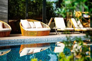 a group of chairs sitting next to a swimming pool at Garden Terrace Fukuoka in Fukuoka