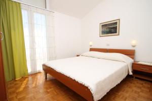 sypialnia z łóżkiem i dużym oknem w obiekcie Apartments with a parking space Makarska - 6667 w Makarskiej