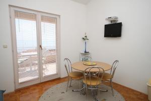 jadalnia ze stołem, krzesłami i telewizorem w obiekcie Apartments with a parking space Makarska - 6667 w Makarskiej