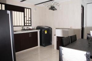 een keuken met een wastafel en een koelkast in de kamer bij RAKIRA SUITES APARTAHOTEL CAMPESTRE in Ráquira