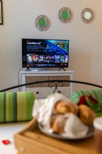 un piatto di pane su un tavolo di fronte a una tv di Casa Domitilla Vista Mare - Spiagge, Storia & Relax Wifi - Netflix a Terracina