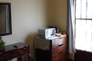 Habitaciones 1 acceso independiente y autonomo Puebla في بوبلا: وجود ميكروويف في خزانة الملابس