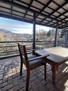 a wooden table and chair on a patio with a view at vila zia in Corbeni