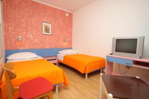 Habitación pequeña con 2 camas y TV. en Apartments by the sea Tucepi, Makarska - 6806 en Tučepi