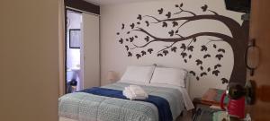 a bedroom with a bed with a tree with birds on it at Hospedaje de Lidia in Lima