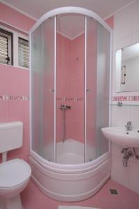 a pink bathroom with a shower and a sink at Apartments by the sea Baska Voda, Makarska - 6848 in Baška Voda