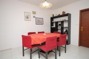 a dining room with a table and red chairs at Apartments by the sea Baska Voda, Makarska - 6848 in Baška Voda +17 photos