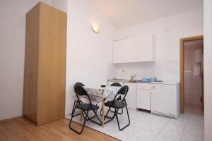 a kitchen with a table and chairs in a room at Apartments by the sea Podaca, Makarska - 6902 in Podaca +22 photos
