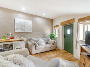 uma sala de estar com um sofá e uma porta verde em Caner Bach Lodge em Bridgend