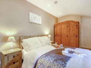 Schlafzimmer mit einem Bett und einem Holzschrank in der Unterkunft Caner Bach Lodge in Bridgend