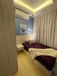 - une petite chambre avec un lit et un rideau dans l'établissement Marassi - El Alamein - Veneto Island - Ulta-Luxury Hotel-Style Villa, à El Alamein