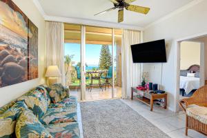 a living room with a couch and a flat screen tv at Menehune Shores 626 in Kihei