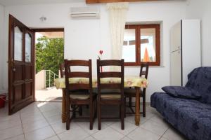 a living room with a table and chairs and a couch at Apartments by the sea Starigrad, Paklenica - 6586 in Starigrad