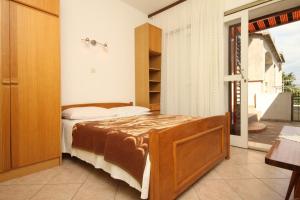 a bedroom with a bed and a door to a balcony at Apartments by the sea Starigrad, Paklenica - 6586 in Starigrad