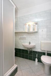 a bathroom with a sink and a toilet and a mirror at Apartments with a parking space Pag - 6461 in Pag