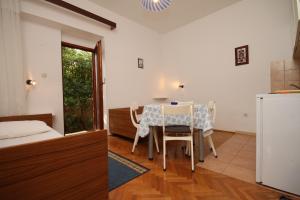 a kitchen and dining room with a table and chairs at Apartments with a parking space Novalja, Pag - 6553 in Novalja +24 photos
