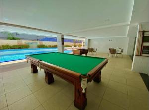 a pool table in a room with a swimming pool at Flat beira mar Tambaú in João Pessoa