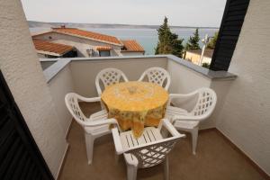 a table and four chairs on a balcony at Apartments and rooms by the sea Starigrad, Paklenica - 6588 in Starigrad