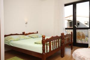 a bedroom with a bed and a window at Apartments and rooms by the sea Starigrad, Paklenica - 6588 in Starigrad