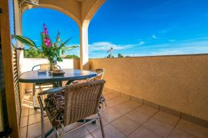 a table and chairs on a balcony with a vase of flowers at Apartments with a parking space Starigrad, Paklenica - 6595 in Starigrad