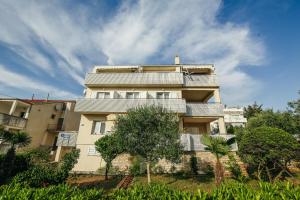 a building with balconies and trees in front of it at Apartments and rooms with parking space Novalja, Pag - 6482 in Novalja