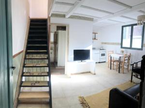 a living room with a staircase and a television at Azul en Lavalle in Azul